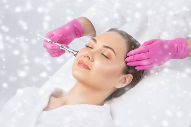 il cosmetologo effettua la procedura di microdermoabrasione sul viso contro l'acne e i punti neri vicino agli occhi. cosmetologia femminile nel salone di bellezza. - dermatology dermabrasion surgery medical foto e immagini stock