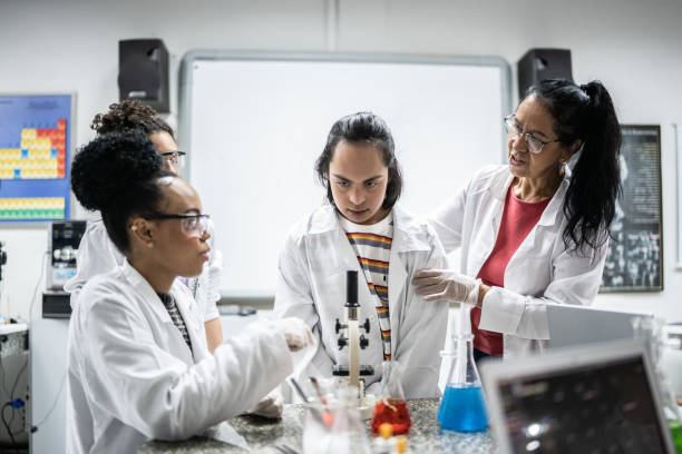 istock Chemistry teacher teaching students in the lab at school - including student with special needs 1356639965