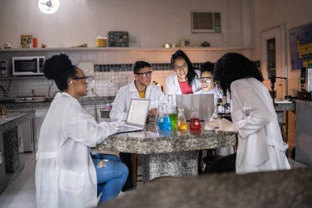 istock Chemistry teacher teaching students in the lab at school 1356639999