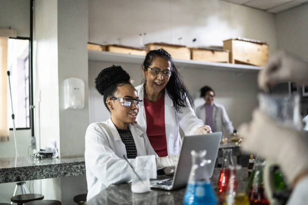 istock Chemistry teacher teaching students in the lab at school or university 1356640025