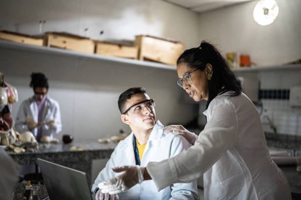 istock Chemistry teacher teaching students in the lab at school or university 1356640034