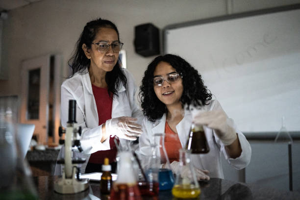 teacher doing an experiment with student in a lab at school or university - professor scientist chemistry teacher imagens e fotografias de stock