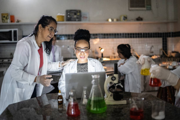 istock Chemistry teacher teaching students in the lab at school or university 1356640048