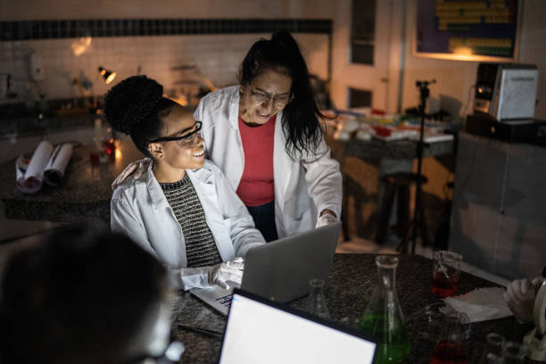 istock Chemistry teacher teaching students in the lab at school or university 1356640051