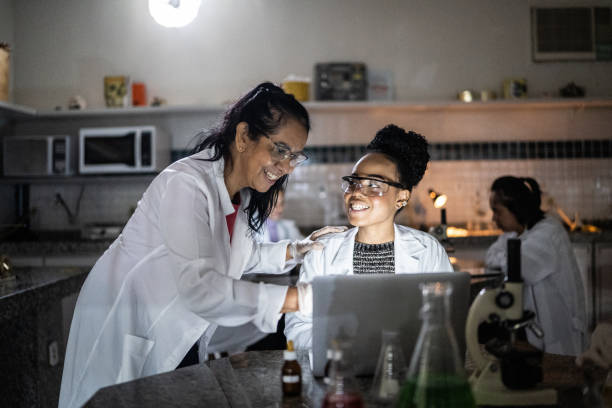 Chemistry teacher teaching students in the lab at school or university