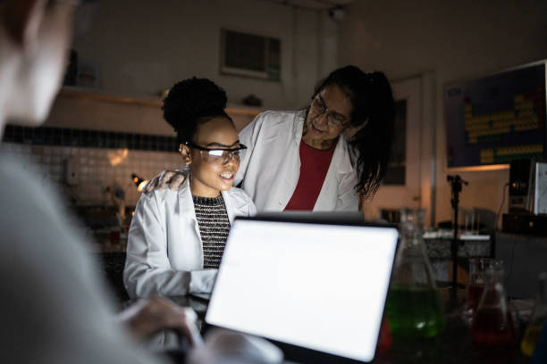 istock Chemistry teacher teaching students in the lab at school or university 1356640120