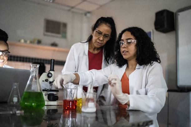 istock Teacher doing an experiment with student in a lab at school or university 1356640151