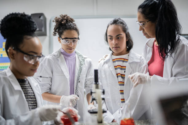 chemistry teacher teaching students in the lab at school - including student with special needs - professor scientist chemistry teacher imagens e fotografias de stock