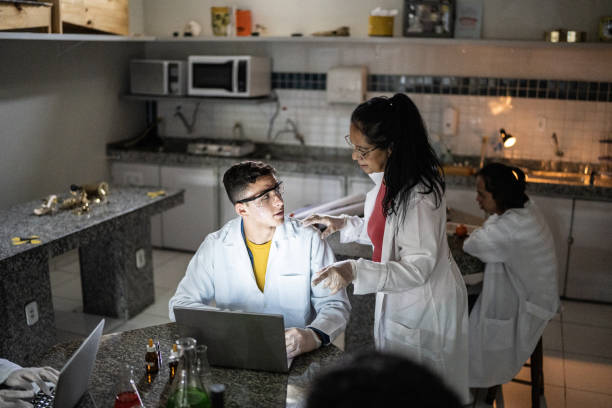 istock Chemistry teacher teaching students in the lab at school or university 1356640164