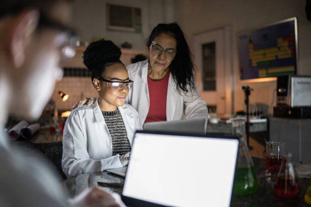 istock Chemistry teacher teaching students in the lab at school or university 1356640236