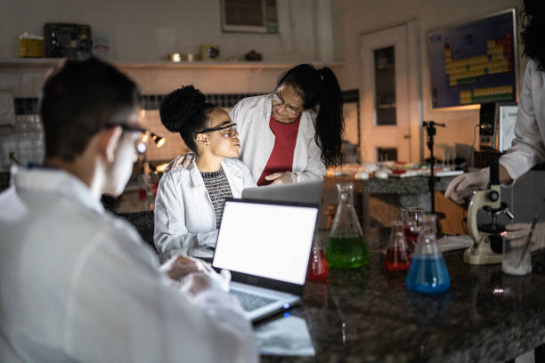 istock Chemistry teacher teaching students in the lab at school or university 1356640258
