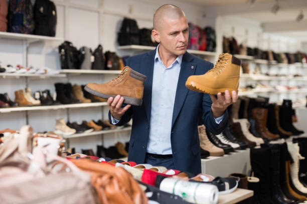 istock Man choosing comfortable spring autumn lace up boots in shop 1356641361