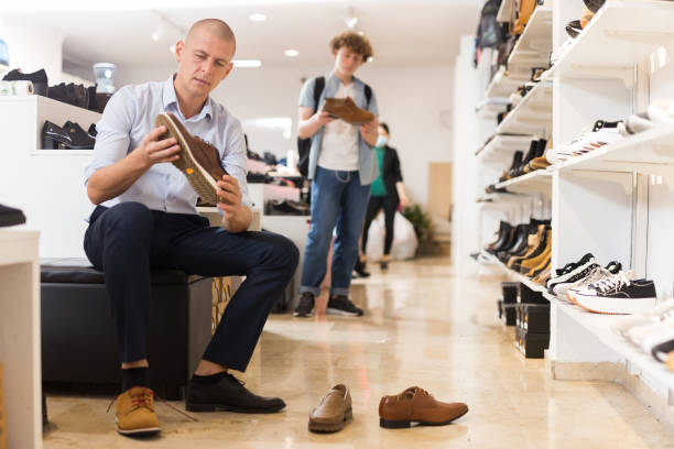 istock Man trying on suede and leather loafers in store 1356641386