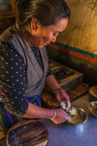 tibetische frau bereitet momos vor, upper mustang, nepal - chinese dumpling vertical dumpling asian culture stock-fotos und bilder