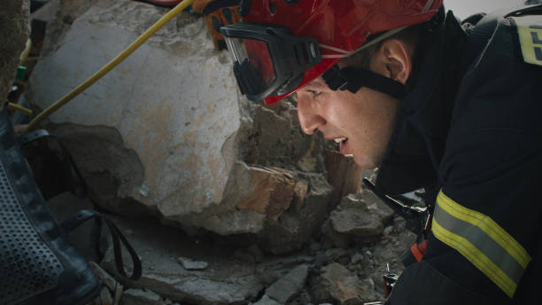 istock Male rescuer examining rubble and talking 1356642942