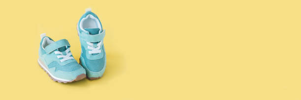 istock Green sneakers on yellow pastel background. Minimal banner. 1356644398