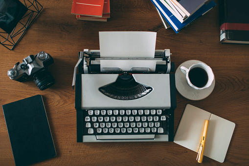 Vintage writing desk with retro typewriter. Top view thirties. Author, writing, journalism concept