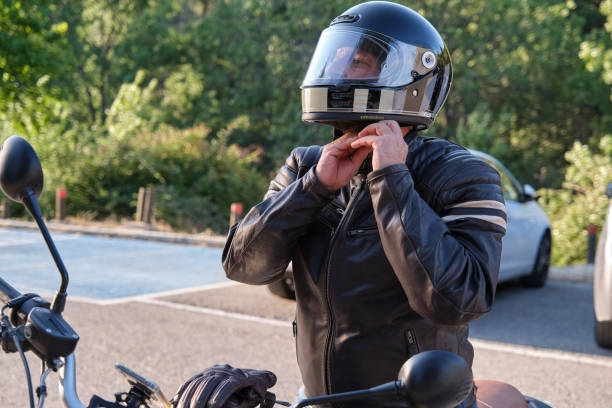 A biker puts on helmet before riding on motorbike stock photo