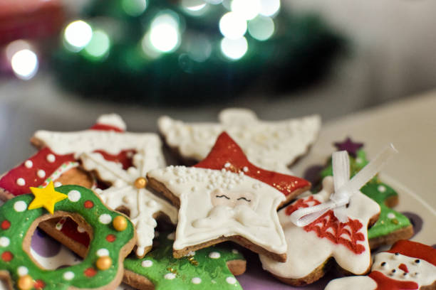 istock Plate with gingerbread cookies next to a Christmas tree 1356647688
