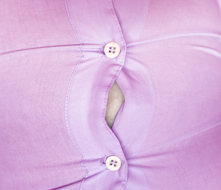 Botones hacia abajo Camisa estirada sobre un vientre photo