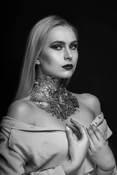 istock Monochrome beauty shoot: awesome blond model posing with foil on her neck 1356649510