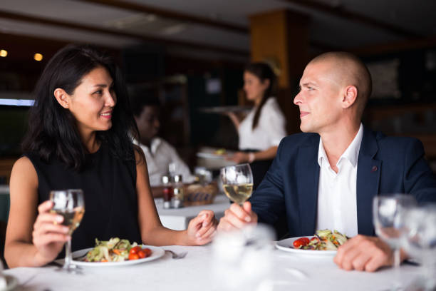 istock Elegant couple enjoying dinner with wine in restaurant 1356649612