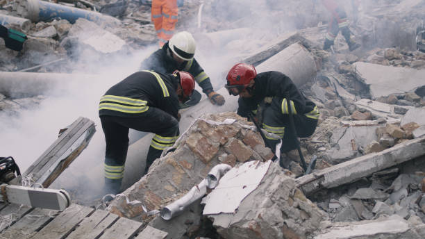 Emergency workers removing rubble together Men in protective uniforms and hardhats removing pieces of broken building during rescue mission after earthquake natural disaster stock pictures, royalty-free photos & images