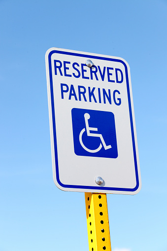 A parking lot sign, marking parking spots reserved for disabled drivers.