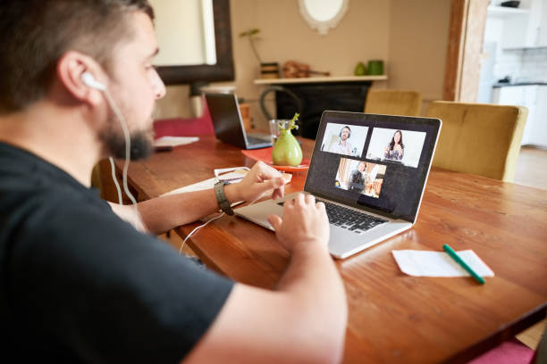 istock Man having online meeting with team while working remotely from home 1356655659