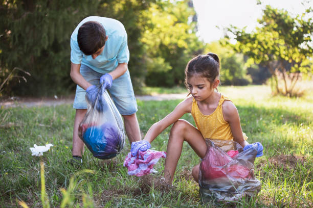 istock Little volunteers picking up trash in the park 1356658110