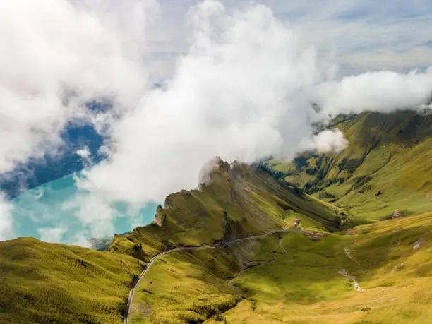 Aerial image of the Brienzer Rothorn steam train ascending onto the summit with Dirrengrind cliff at the background and the autumn fog rising from the Brienz Lake site