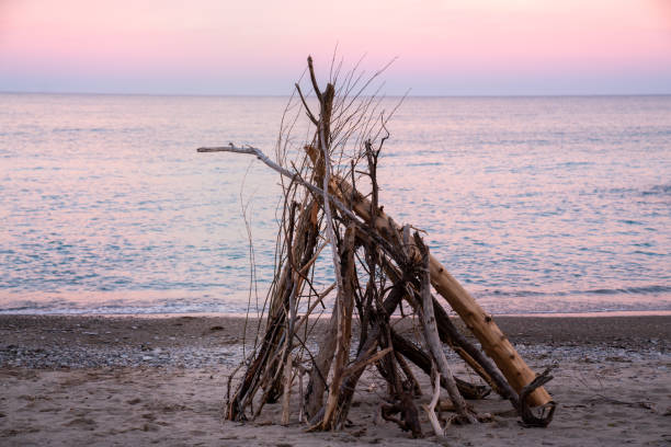 Porto Caleri coastal botanical garden and wild beach, Veneto, Italy. Sunset landscape with driftwood hut.