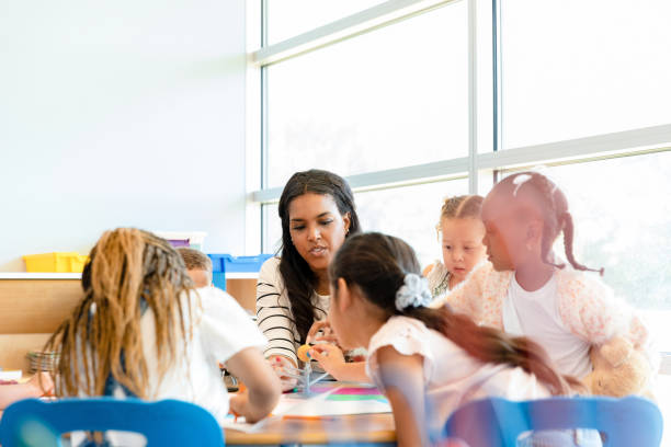 istock Kindergarten teacher helps children understand solar system 1356661331