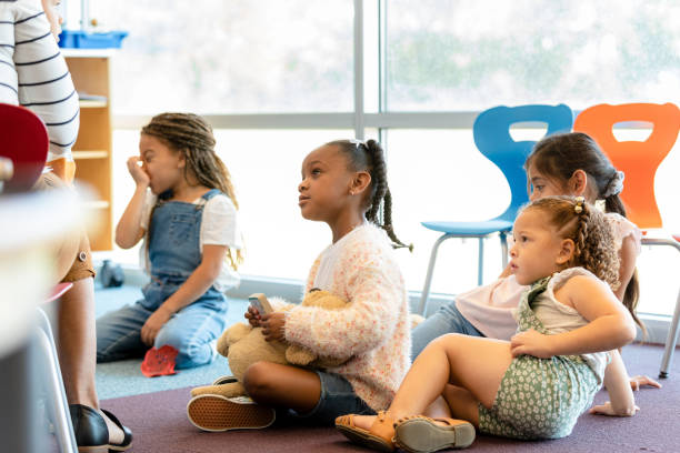 istock Busy preschool age children sit on classroom floor 1356661384