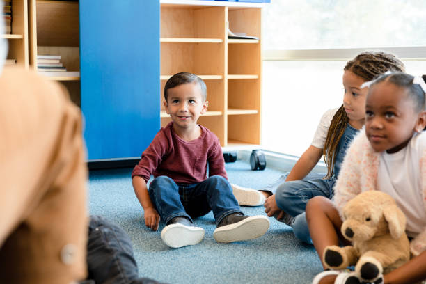 istock Kindergarten children sit on floor during story time 1356661388