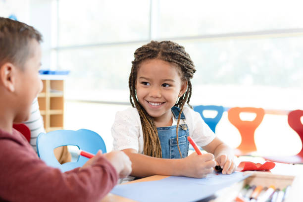 istock Children smile at each other during art class 1356661390