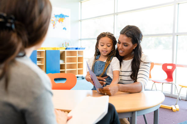 istock Mom looks at daughter's artwork during parent-teacher conference 1356661521