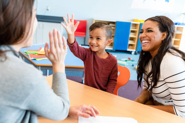 istock Preschool teacher gives boy high five 1356661529