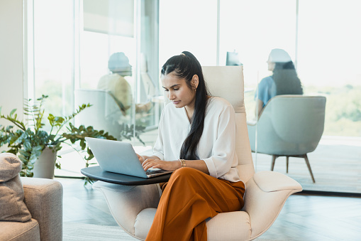 Mujer de negocios usa computadora portátil en una oficina de concepto abierto photo