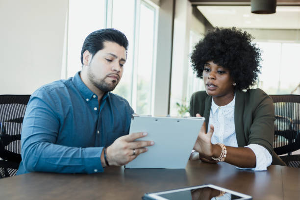 istock Business people discuss financial document 1356661725