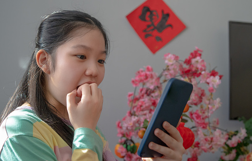 Teenage girl receiving digital red envelope from parent during Chinese new year