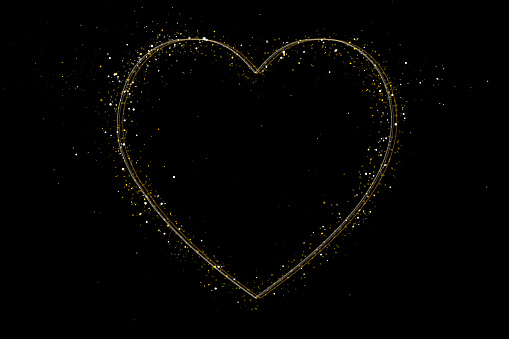 Shiny golden sparks around golden linear hearts over black background.