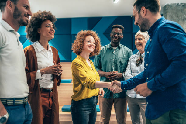 Handshake for the new agreement Happy businesswoman shaking hands with her colleague on a meeting in the office. employee introduction stock pictures, royalty-free photos & images