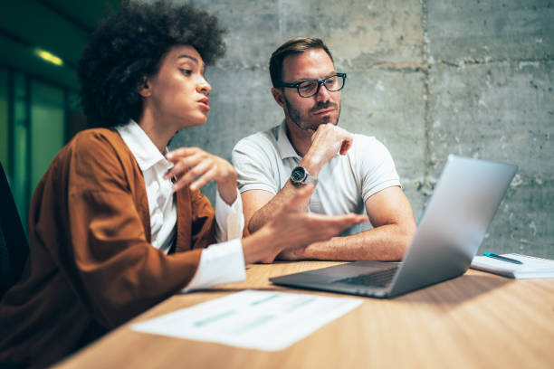 istock Two business people working together in office 1356670654