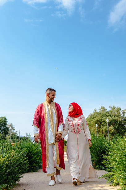 istock arab muslim couple walking in a garden while looking each other 1356674626