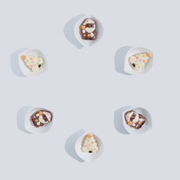 istock Flat lay composition with Christmas chocolate and cookies in a circle, in mini bowls on white background. 1356675482