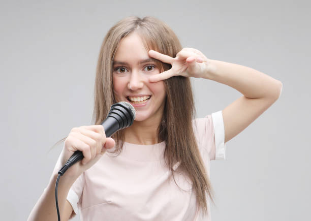 istock Beauty model girl singer with a microphone 1356676582