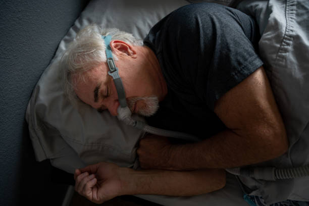 istock Mature Man With Sleep Apnea Wearing A CPAP Mask In Bed Sleeping 1356680018