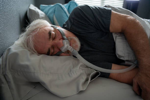 istock Mature Man With Sleep Apnea Wearing A CPAP Mask In Bed Sleeping 1356680020