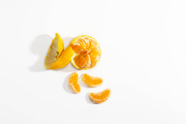 Half peeled tangerine and three tangerine wedges on a white background. Isolate. Life style. Clos ap. Horizontal photo. High quality photo